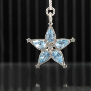Penjoll en plata de llei amb forma d'estrella i les puntes són pedres blaves. <br>