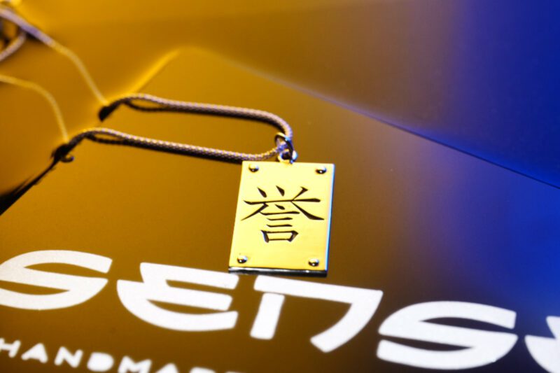 Colgante en forma de palca con el kanji honor grabado