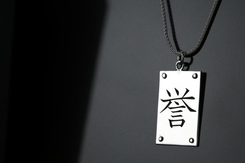 Colgante en forma de palca con el kanji honor grabado
