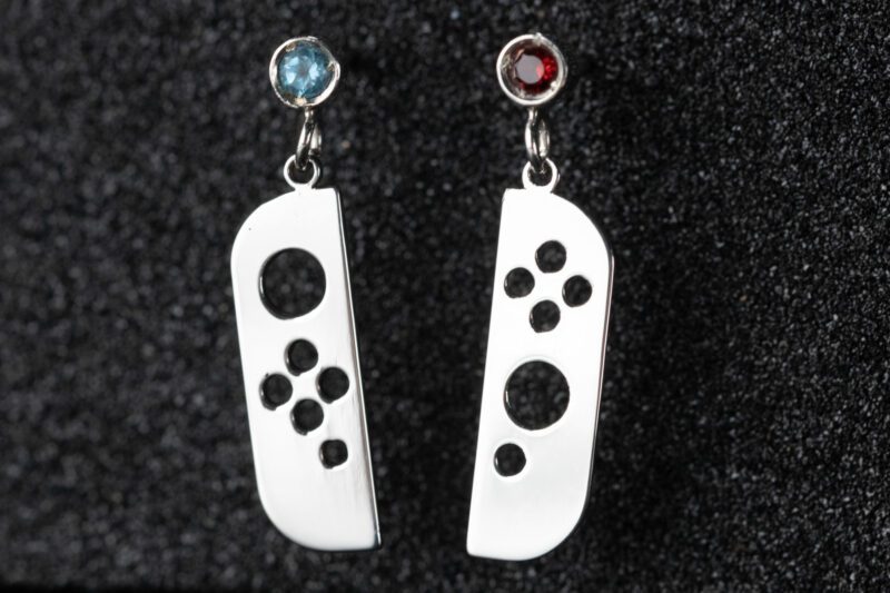 Pendientes en forma de mando de consola con dos piedras, roja y azul, engastadas