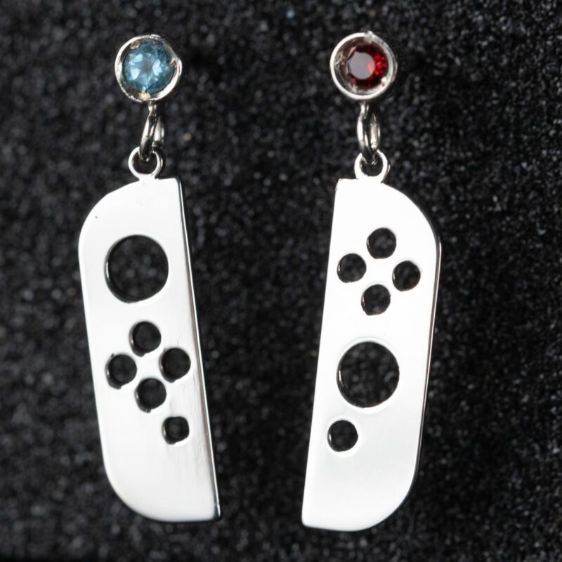 Pendientes en forma de mando de consola con dos piedras, roja y azul, engastadas