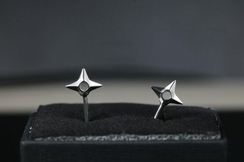 Pendientes en forma de shuriken hechos en plata de ley.